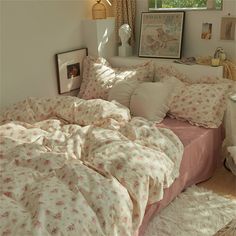 an unmade bed in a bedroom with pink comforter and pillows on the floor