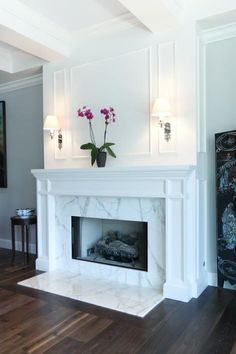 a living room with a white fireplace and wooden floors