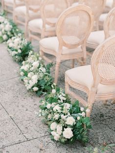 rows of chairs lined up with flowers and greenery