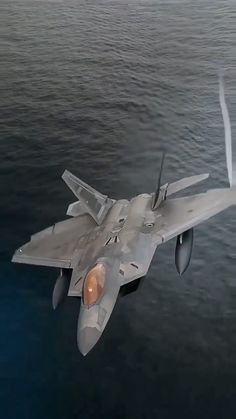 a fighter jet flying over the ocean