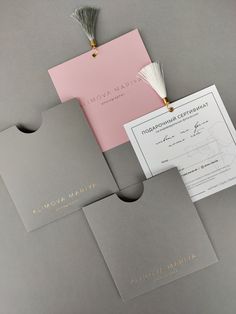 the wedding stationery is laid out neatly on top of each other, including an envelope with a tassel