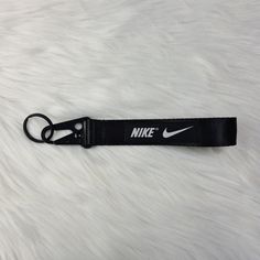 a nike lanyard keychain is shown on a white fur surface