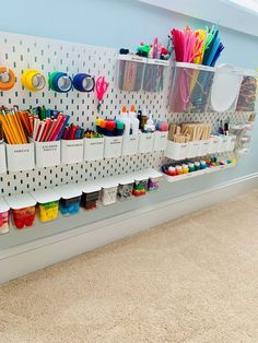 the wall is filled with lots of craft supplies and storage bins for pens, pencils, markers, scissors