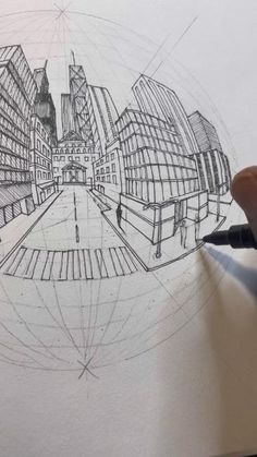 someone is drawing a cityscape on paper