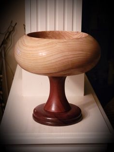 a wooden bowl sitting on top of a white table next to a radiator