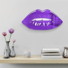 a shelf with vases and flowers on top of it next to a wall mounted mirror