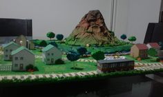 a cake that looks like a small town with houses and mountains on top of it