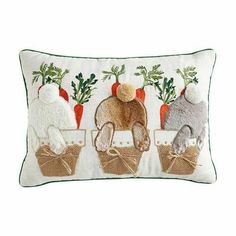 three stuffed animals sitting in baskets on a white pillow with carrots and radishes