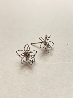 Small metal flower wire stud earrings.  Unique earrings for a unique person. Not intended for children ages 13 and under.   Also, for many items we can accommodate large orders, so please send us a message. Whimsical Silver Flower Earrings, Whimsical Handmade Silver Flower Earrings, Whimsical Silver Flower Earrings With Ear Wire, Silver Whimsical Flower Earrings, Metal Flower Charm Earrings As Gift, Hypoallergenic Metal Flower Earrings, Nickel Free Flower Shaped Earrings As Gift, Nickel Free Flower Earrings As Gift, Nickel-free Flower Shaped Earrings As Gift