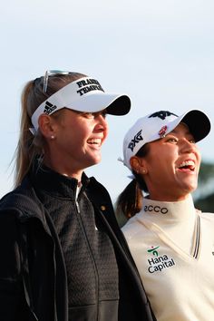 two women standing next to each other with hats on their heads and one has her arm around another woman's shoulder