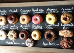 a black board with different types of doughnuts on it