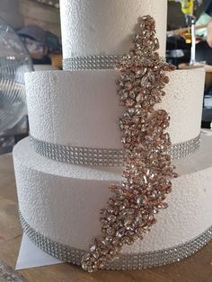 a three tiered wedding cake decorated with crystals