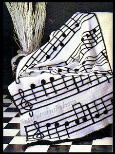 a black and white checkered table cloth with musical notes on it, next to a potted plant