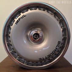 a wheel that is sitting on top of a wooden table and has words written on it