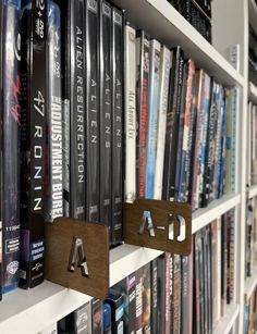 a book shelf filled with lots of books next to a wall full of other books