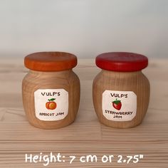 two jars with labels on them sitting on a table