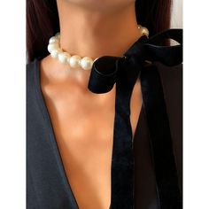 This unique faux pearl necklace is an eye catching beauty that will staple your elegant style. Perfect to complete a glamorous look. Features: Faux Pearl with Velvet self tie. Size: Line of pearls - 21.5", Velvet tie 7.75" Color: Ivory/Black Elegant Pearl Chain Choker For Party, Chic Adjustable Pearl Necklace, Chic Pearl White Necklace For Party, Chic Pearl White Pearl Necklace For Party, Elegant Adjustable Pearl Necklace For Evening, Chic Beaded Pearl Necklace, Chic Evening Pearl Necklace, Elegant Adjustable Pearl Choker, Adjustable Pearl Choker For Formal Occasions