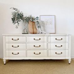 a white dresser with some plants on top