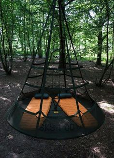 a hanging bed in the middle of a forest