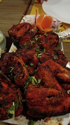 chicken wings with garnishes on a white plate