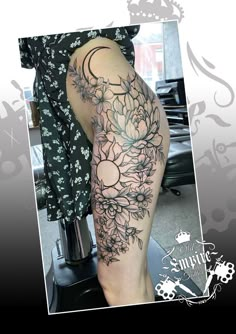 a woman's leg with flowers on it and the moon in the sky behind her