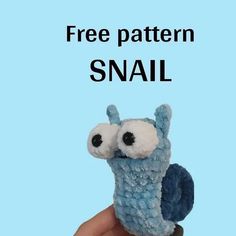 a hand holding a small stuffed animal with the caption free pattern snail on it