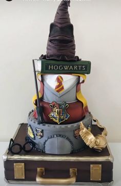 a cake made to look like a wizard hat with harry potter's crest on top