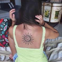 a woman with a sun tattoo on her back