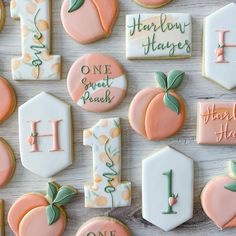 many decorated cookies are arranged on a white table with pink and green accents, including one for the letter h