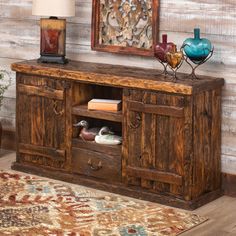 a large wooden entertainment center with drawers and doors on the front, in a living room