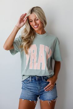 We love the message on the Sage Pray Tee! This comfy tee is designed with a soft and stretchy knit. It features a crew neckline, short sleeves, a relaxed fit, and the word "Pray" on the front. Style the Sage Pray Tee with your favorite denim and sneakers for a casual daytime look! Comfort Colors Soft + Stretchy Knit Fabrication "Pray" Graphic Crew Neckline Short Sleeves Relaxed Fit 100% Cotton Machine Wash Cold, Tumble Dry Low Model is 5'4" and wearing a Medium. For an Oversized Fit, We Recommen Spring T-shirt With Lettering, Short Sleeve, Spring T-shirt With Lettering, Everyday Short Sleeve Tops With Lettering, Everyday Crew Neck Tops With Lettering, T Shirt Flat Lay, Sage Color, The Message, Distressed Denim Shorts, Large Bust