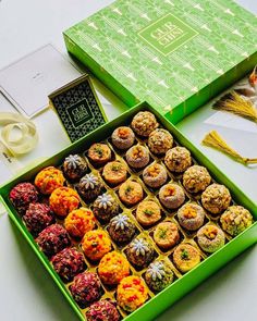 a green box filled with lots of different flavored treats on top of a table