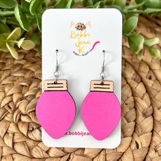 the pink and wooden earrings are on display