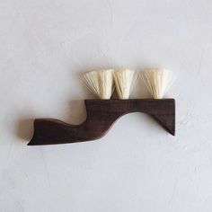 three white shaving brushes sitting on top of a wooden shelf