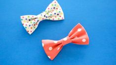 two small bow ties sitting on top of a blue table next to each other with polka dots