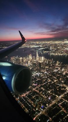 an airplane wing flying over a city at night