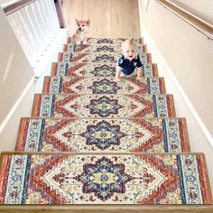 a baby sitting on top of a carpeted stair case next to a small dog