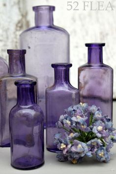 purple vases with flowers in them sitting on a table next to each other and the words 52 flea written below