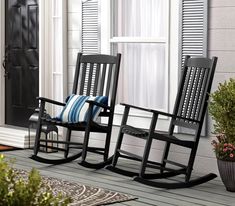 two rocking chairs sitting on a porch next to a potted plant