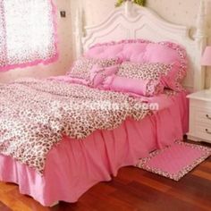 a bed with pink sheets and leopard print on it