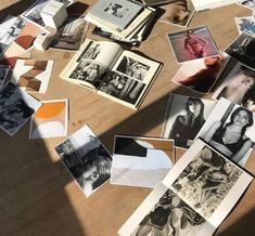 many black and white photographs are spread out on the floor