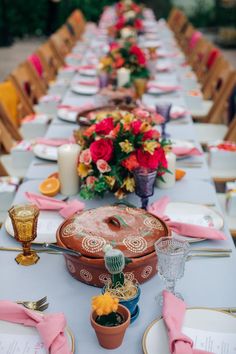 a long table is set with plates and place settings