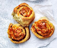 three pastries sitting on top of white paper