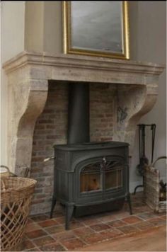 a wood burning stove sitting inside of a living room next to a painting on the wall