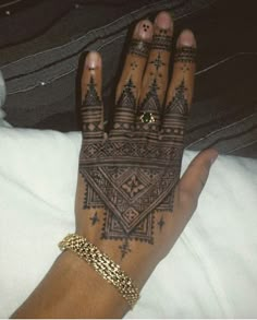 a woman's hand with henna tattoos on it