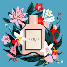 a bottle of gucci bloom perfume surrounded by flowers and other decorative objects on a blue background