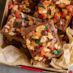 several pieces of chocolate with nuts and other toppings in a cardboard box on a table