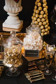 a table topped with lots of chocolate covered candies and candy in glass jars on top of each other