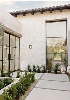 an outside view of a house with some plants