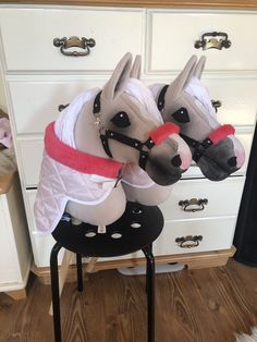 two stuffed horses sitting on top of a chair